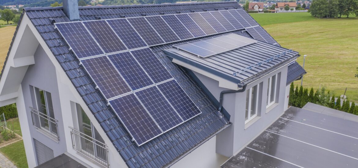 High angle shot of a private house situated in a valley with solar panels on the roof A high angle shot of a private house situated in a valley with solar panels on the roof