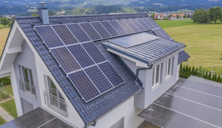 A high angle shot of a private house situated in a valley with solar panels on the roof