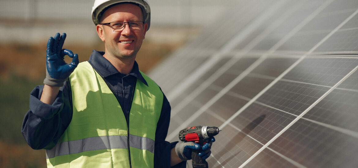 Man in a white helmet near a solar panel Engineer in a white helmet. Man near solar panel.