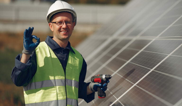 Engineer in a white helmet. Man near solar panel.