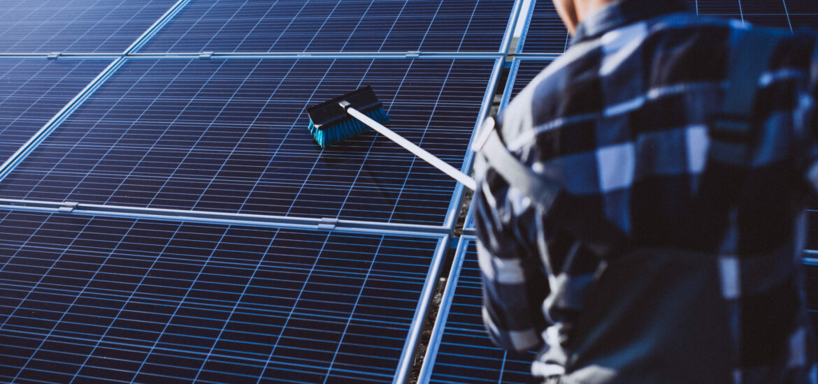 Man worker in the firld by the solar panels Man worker in the firld by the solar panels
